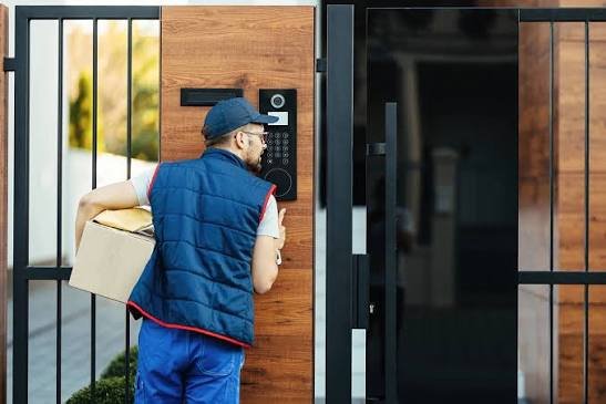 Pessoa utilizando interfone em uma entrada